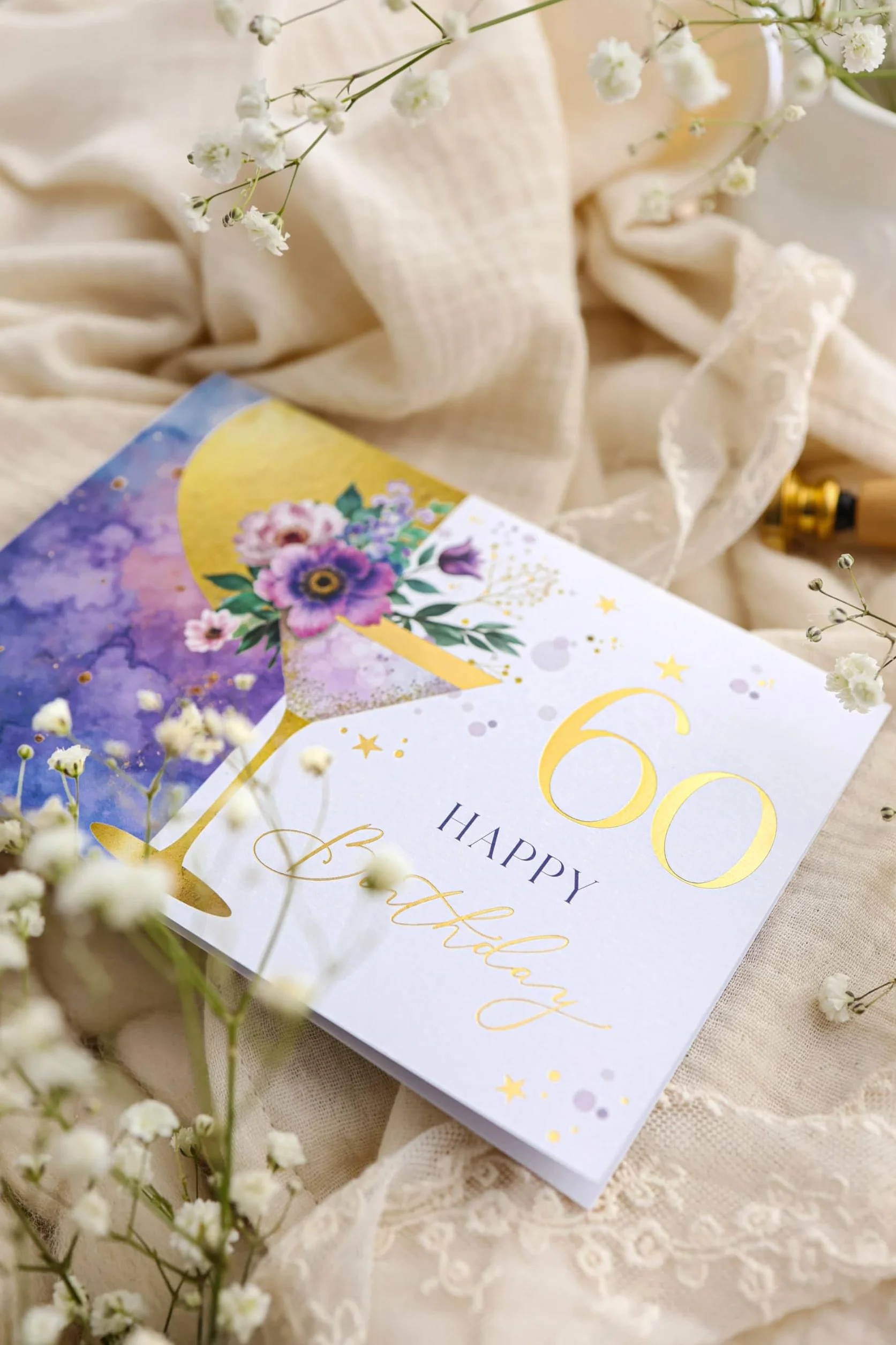 Carte anniversaire 60 ans femme élégante avec illustration florale martini et enveloppe pastel